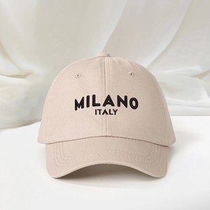 Detailed close-up of MILANO ITALY embroidery on a beige cotton baseball cap with twill texture