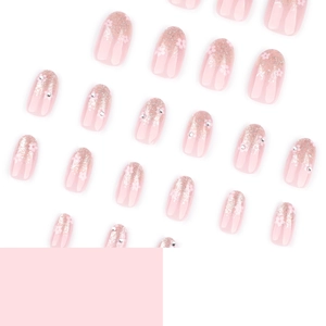 Pink gradient glitter press-on nails with floral art and rhinestones on white background