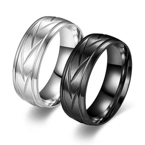 Detail of silver and black brushed stainless steel rings with minimalist V-groove patterns