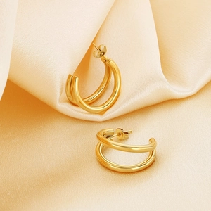Chic double-layered gold stainless steel hoop earrings on elegant champagne silk background