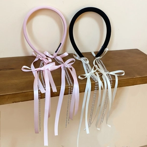 Detail of fabric bow headbands with crystal bead tassels in pink and black colors