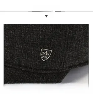 Close-up of thick grey thermal knit fabric with mountain badge and 1985 engraving