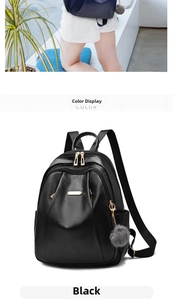 Detail view of black matte PU leather backpack featuring dual zippers and grey pompom charm