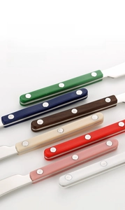 Detail view of colorful ABS handles with triple rivet reinforcement on butter knives