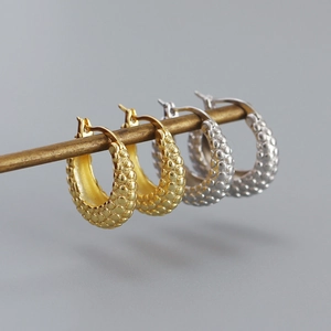 Close-up of S925 sterling silver earrings with textured finish in gold and silver