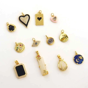 Macro shot of 18k gold plated heart, evil eye, and star pendants with enamel detail