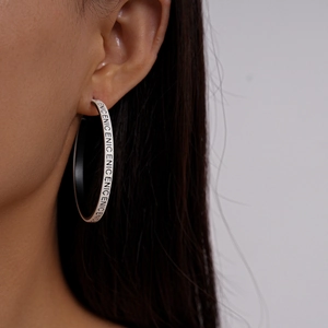 Détail macro de boucles d oreilles créoles avec motif géométrique Enicenic noir et blanc