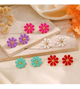 Detailed view of colorful enamel daisy stud earrings in pink, purple, white and teal