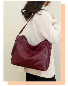 Burgundy PU leather tote with geometric stitching and tassel detail worn on shoulder