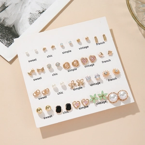 Close-up of 20 pairs earring set with faux pearls, rhinestones and heart designs