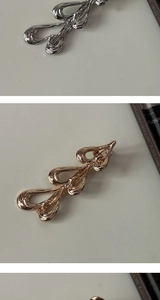 Detailed view of hollow metal butterfly hair clips in shiny gold and silver finishes