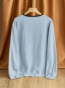 Detail of light blue linen-cotton shirt back showing texture and black collar trim