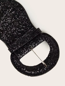 Close-up of black sequined wide elastic belt featuring a metallic pin buckle
