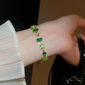 Detail view of gold bracelet with emerald green and lime geometric zircon stones