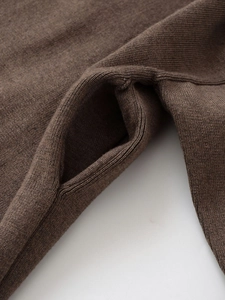 Nahaufnahme der Taschennaht und feine Strickstruktur einer braunen Strickjacke