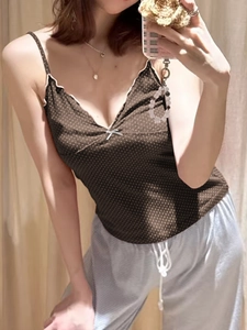 Mirror selfie showing the fit of a black polka dot camisole with grey striped trousers
