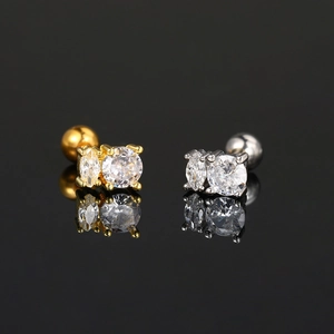 Detail of silver and gold cartilage studs with double sparkling cubic zirconia