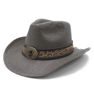 Macro detail of dark brown woven cowboy hat with gold vine embroidery and gemstone buckle