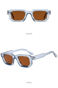 Detail of square sunglasses with light blue transparent frames and orange lenses