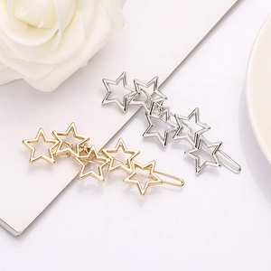 Elegant gold and silver hollow star-shaped metal hair clips on white rose background