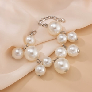 Detail of faux pearl bracelet with silver metal chain on elegant satin background