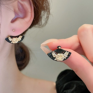 Detailed view of fan-shaped black earrings with gold rose relief and silver needle studs