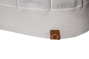 Macro dell'orlo a costine e dell'etichetta in tessuto su polo in maglia grigio chiaro
