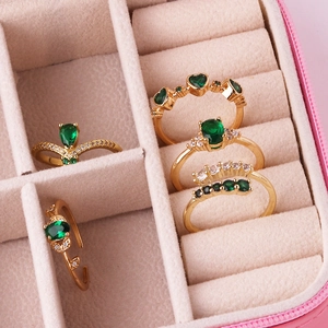 Detail of five vintage emerald and zircon rings in a jewelry box for women