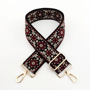 Macro view of floral embroidery and golden metal lobster clasps on 5cm woven bag strap
