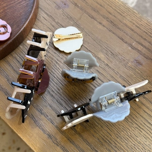 Detailed collection of acetate dog-shaped hair claws in tortoiseshell and solid colors