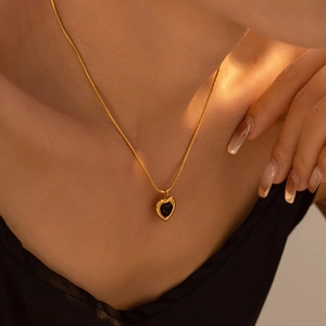 Vintage gold heart necklace with black gemstone on model for professional fashion display