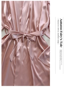 Vue détaillée de la texture du pyjama en satin rose avec nœud à la taille