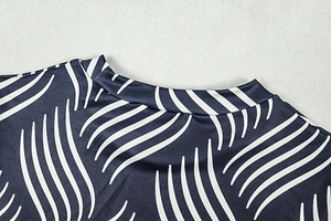 Detail of navy blue wavy striped fabric and mock neck stitching on a two-piece set