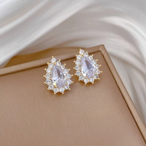 Detail of teardrop zircon earrings with halo diamond setting on gold titanium steel