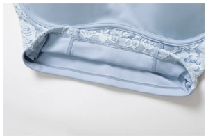 Detailed close-up of light blue sports bra with lace stitching and reinforced seams