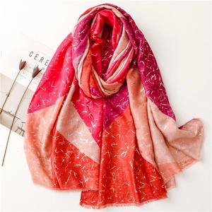 Detail of warm-toned geometric color block scarf with decorative gold foil print textures