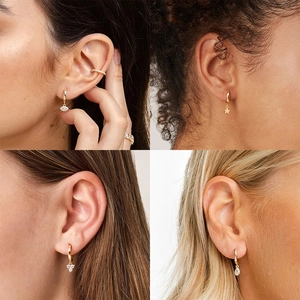 Detailed views of four gold hoop earring styles with eye, star, flower and zircon drops