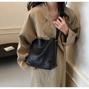 Detailed view of black crocodile pattern faux leather shoulder bag with wide strap