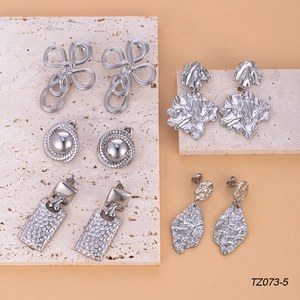 Irregular textured leaf earrings and geometric silver studs set on stone blocks
