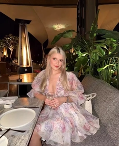 Détail d'une robe fleurie à col en V et manches bouffantes dans un décor de restaurant