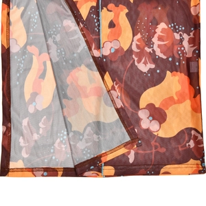 Détail du tissu en tulle avec imprimé floral orange et coutures d'ourlet sur une robe