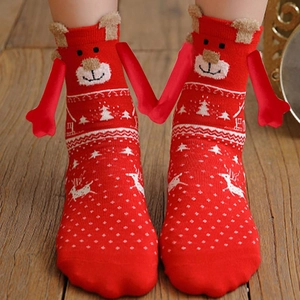 Red Christmas knit socks featuring reindeer patterns and 3D ears on a wooden background