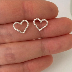 Detailed view of silver heart stud earrings with twisted rope texture held on fingers