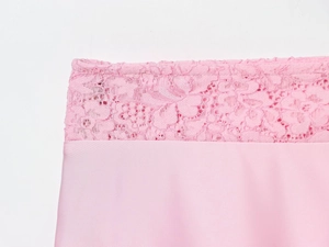 Macro detail of delicate pink lace trim and satin fabric on the sexy camisole dress