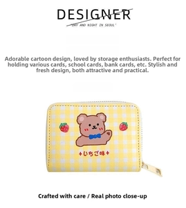 Detail view of yellow checkered card holder featuring cartoon bear and strawberry pattern