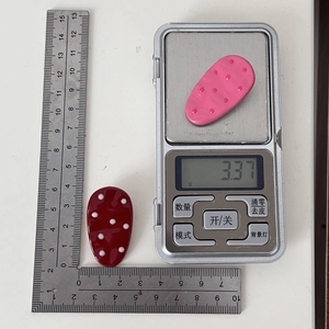 Detailed view of pink and red polka dot hair clips showing size and 3.37g weight