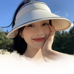 Outdoor beach shot of a beige UPF 50+ wide brim sun hat with full face UV protection