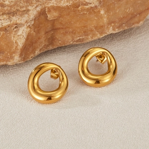 Detailed close-up of golden wavy hoop earrings with unique irregular texture on base