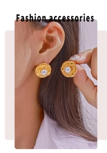 Detail of gold twisted rope earrings with white pearl inlay shown on model's ear