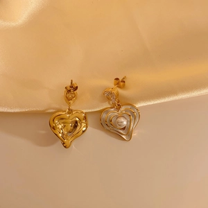 Macro detail of asymmetric heart earrings with liquid gold texture, pearls and zircons